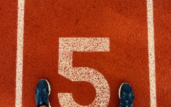 Runner's feet on track lane 5 at the finish line, symbolizing completion and success.